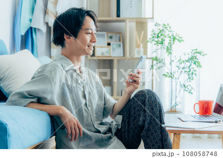 リビングでスマホを使う男性 リビングでスマホを使う男性 108058748