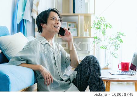 リビングでスマホで電話するミドルの男性 108058749