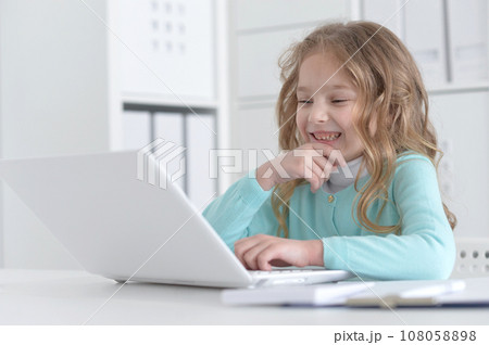 Cute and happy little girl children using laptop computer Cute and happy little girl children using laptop computer 108058898