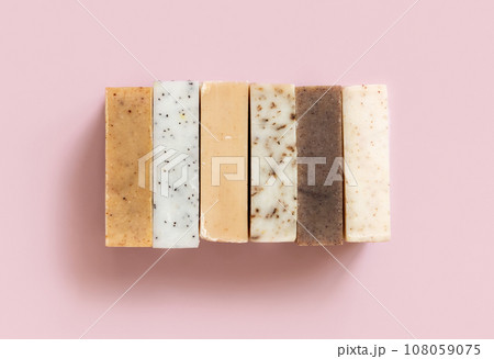 Beige and brown handmade soap bars on light pink top view. Natural herbal product for SPA Beige and brown handmade soap bars on light pink top view. Natural herbal product for SPA 108059075