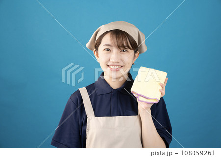 ブルーバックでハンディモップを持つハウスクリーニングの女性作業員 108059261