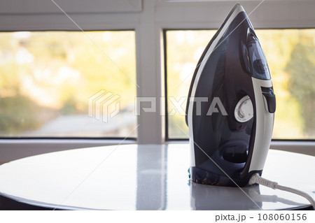 Electric steam iron on a light background 108060156