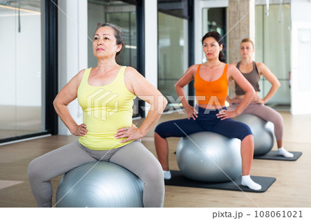 Four women sitting on swiss balls 108061021