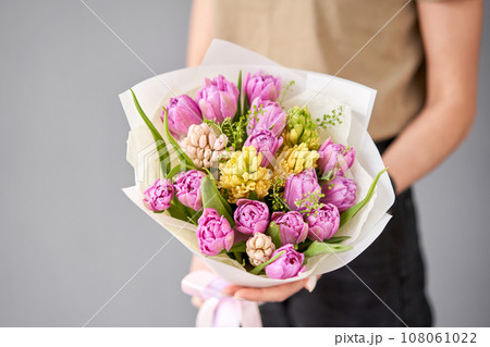 Tulips in woman hand. Spring bouquet of red tulips in hands. Bunch of fresh cut spring flowers 108061022