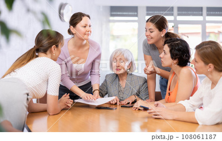 Smiling woman conducting informal work meeting with female colleagues Smiling woman conducting informal work meeting with female colleagues 108061187