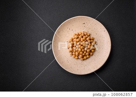 Delicious canned chickpeas in a ceramic plate on a dark concrete background 108062857
