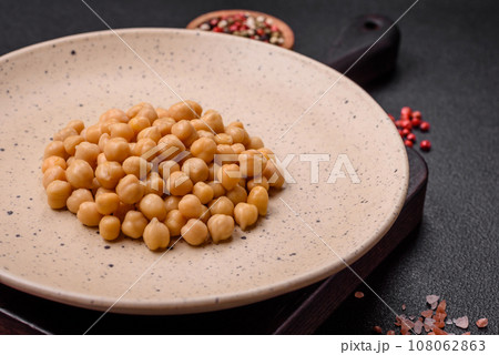 Delicious canned chickpeas in a ceramic plate on a dark concrete background Delicious canned chickpeas in a ceramic plate on a dark concrete background 108062863