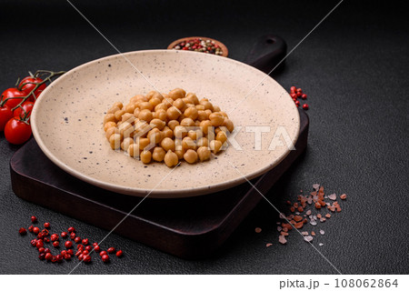 Delicious canned chickpeas in a ceramic plate on a dark concrete background 108062864