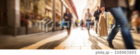 Busy shopping street in the city. Rush hour. Motion blurred crowd of shopping walking on busy fashion shop street. Crowd of people shoppers walking in the streets blurred background 108063805