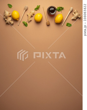 Composition with lemons, mint, ginger, honey in glass jar and honey wooden dippers top view. Food for immunity stimulation and against seasonal flu. Healthy natural remedies to boost immune system 108063822