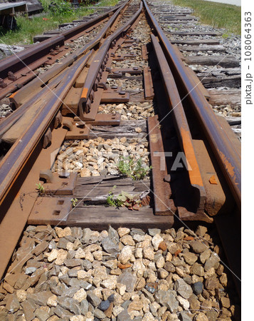 Railroad tracks running into distance with a track switch 108064363
