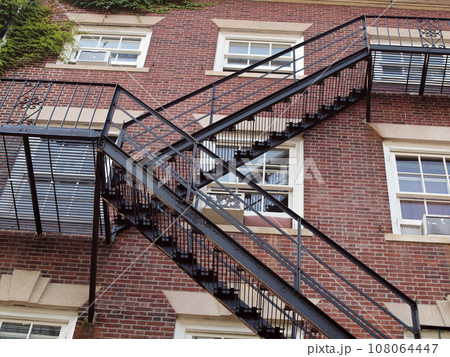 Fire exit on the side of old red brick apartment 108064447