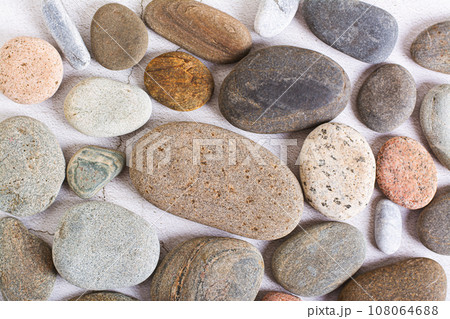 Flat lay background of smooth sea stones on a light background top view Flat lay background of smooth sea stones on a light background top view 108064688