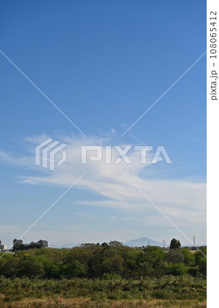 渡良瀬川から望む秋の空に浮かぶ白い雲、遠くに山：埼玉県加須市（旧北川辺町）（縦構図） 108065412