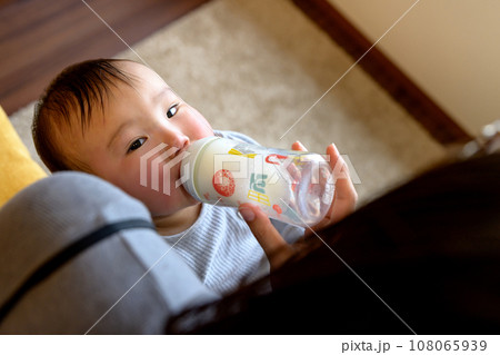 母親に抱っこしてもらい、ミルクを飲む赤ちゃん　授乳　あやす　乳幼児　育児　0歳乳幼児 108065939