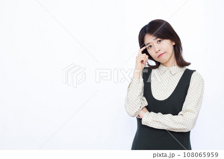 白い背景の前で頭を抱えて悩む30代の女性 白い背景の前で頭を抱えて悩む30代の女性 108065959