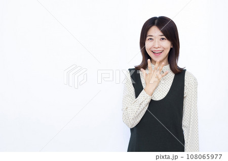 白い背景の前で笑顔で驚いている30代の女性 白い背景の前で笑顔で驚いている30代の女性 108065977