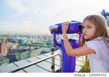 a teenage girl looks into the Binoscope from the observation deck at a height. a teenage girl looks into the Binoscope from the observation deck at a height. 108066350