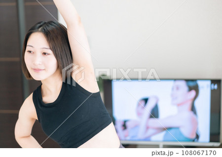 リビングでオンラインレッスンを受ける若い女性 108067170