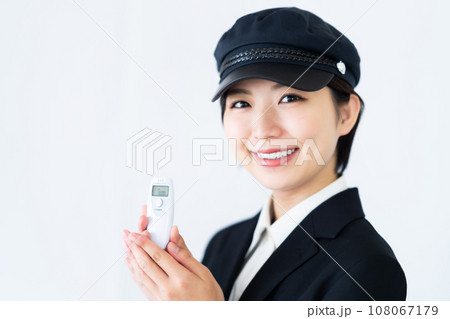 運転前にアルコールチェックをする若い女性ドライバー　白バック 108067179