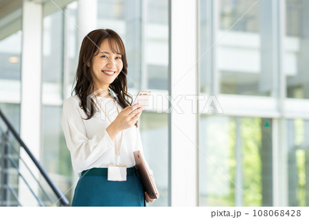 オフィスでスマホを見る若い女性 オフィスでスマホを見る若い女性 108068428