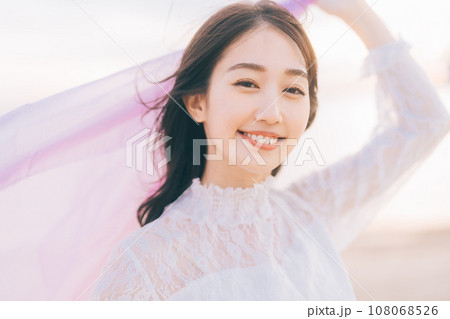 夕日背景の女性ポートレート 108068526