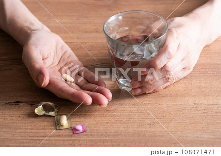 薬を飲む手 108071471