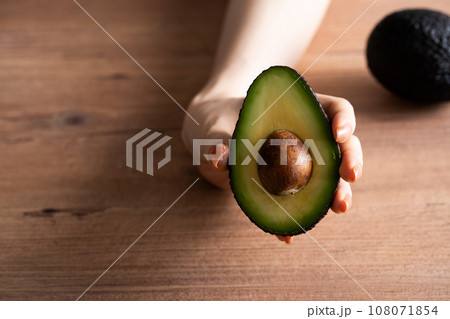 カットしたアボカドを持つ手 108071854