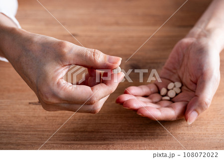 錠剤を持つ手元 108072022
