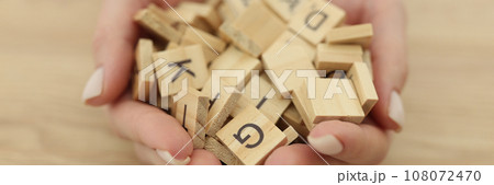 Hands of woman with neat manicure holding cubes with letters Hands of woman with neat manicure holding cubes with letters 108072470