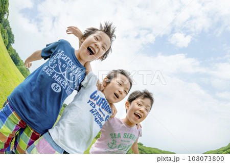 公園の草地で遊ぶ小学生たち 108073800
