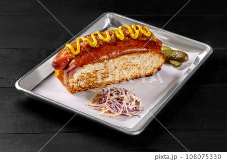 Hot dog in toasted bread with smoked sausage, caramelized onions and mustard sauce 108075330