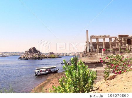 Temple of Isis on Agilkia Island (Philae) and boats on the Nile river, reservoir of Aswan Low Dam, Egypt. Summer vacation, relaxing on cruise ships Temple of Isis on Agilkia Island (Philae) and boats on the Nile river, reservoir of Aswan Low Dam, Egypt. Summer vacation, relaxing on cruise ships 108076869