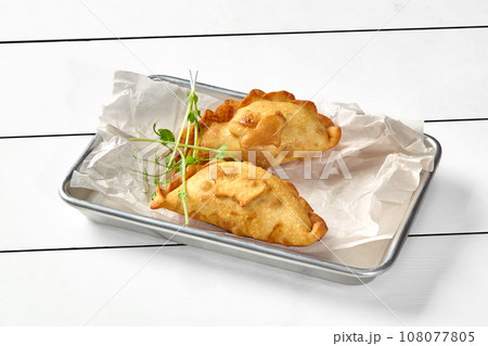 Savory puff pastry turnovers filled with salmon, spinach, cream cheese and herbs 108077805