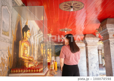 asian woman travel and see to gold buddha statue at chiangmai Thailand in summer season asian woman travel and see to gold buddha statue at chiangmai Thailand in summer season 108078598