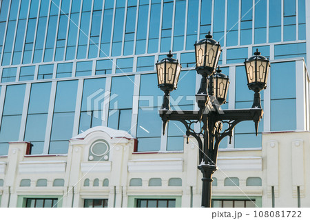 Street light in city winter season on background a glass facade building. Copy space and empty place for text and advertising Street light in city winter season on background a glass facade building. Copy space and empty place for text and advertising 108081722