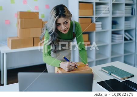 Starting small business entrepreneur of independent Asian female online seller packing products to send to customers and SME delivery concept. 108082279