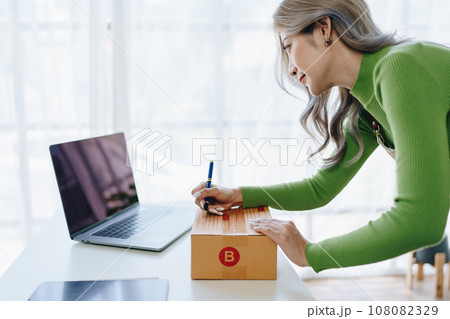 Starting small business entrepreneur of independent Asian female online seller packing products to send to customers and SME delivery concept. 108082329