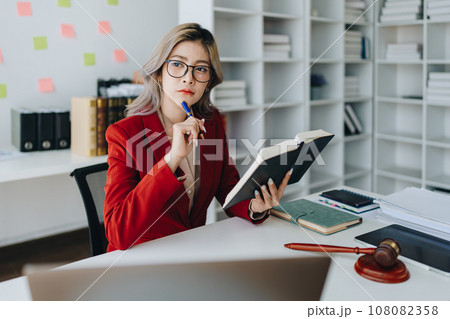 Portrait of a Asian woman lawyer studying a lawsuit for a client before going to court. 108082358