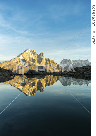 Silhouette of Man, Mountains and Reflection in Lac Blanc Lake at Sunset. Golden Hour. French Alps Silhouette of Man, Mountains and Reflection in Lac Blanc Lake at Sunset. Golden Hour. French Alps 108086808