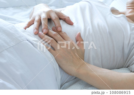 Young man uses his hands to hold his stomach and has a severe stomachache.on isolated white background 108086915