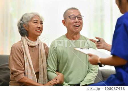Smiling senior couple listening attentively to nurse or general practitioner explaining therapy details during home visit Smiling senior couple listening attentively to nurse or general practitioner explaining therapy details during home visit 108087438