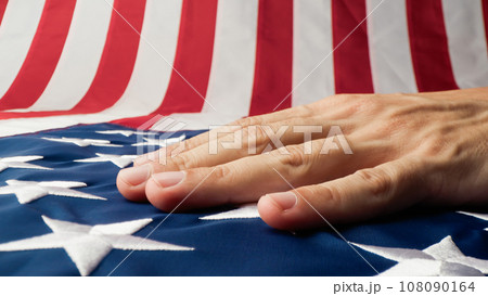 Hand caressing the stars and stripes of a USA flag  108090164