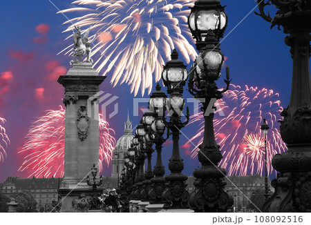 Celebratory colorful fireworks over the Lamp posts on Alexander III Bridge. Paris, France. This arch bridge is one of the most beautiful river crossings in the world 108092516