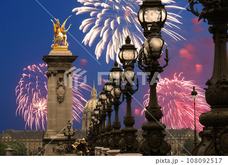 Celebratory colorful fireworks over the Lamp posts on Alexander III Bridge. Paris, France. This arch bridge is one of the most beautiful river crossings in the world 108092517