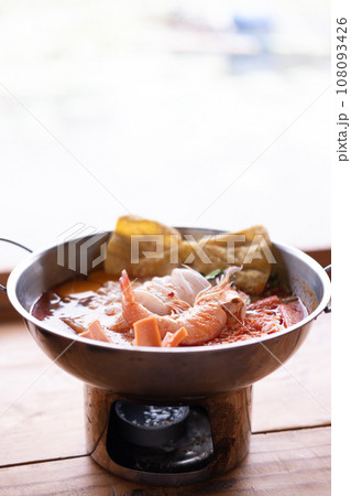 Seafood Tom Yum, hot and sour Thai soup with squid, shrimp served in hot pot 108093426