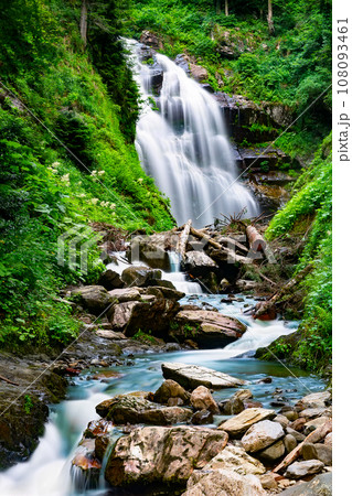 Waterfall cascade on mountain rocks. A mountain waterfall flows over the rocks. Waterfall cascade on mountain rocks. A mountain waterfall flows over the rocks. 108093461