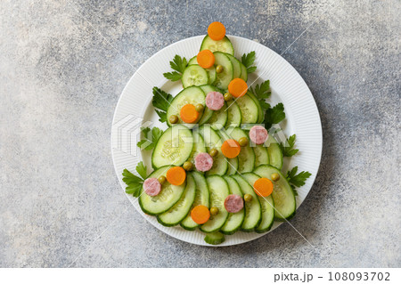 Christmas tree from a salad olivier on a gray stone background. Christmas appetizer. View from above. 108093702