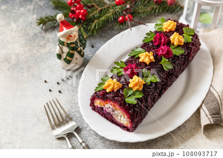 Festive layered shuba salad. Traditional Russian Christmas New Year vegetable salad roll with herring and boiled vegetables. Copy space. 108093717