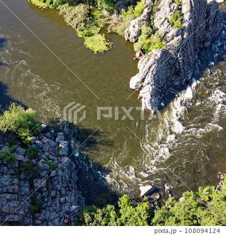 A bend of the Southern Bug river called Integral from a bird's eye view. A picturesque river among the rocky terrain. 108094124